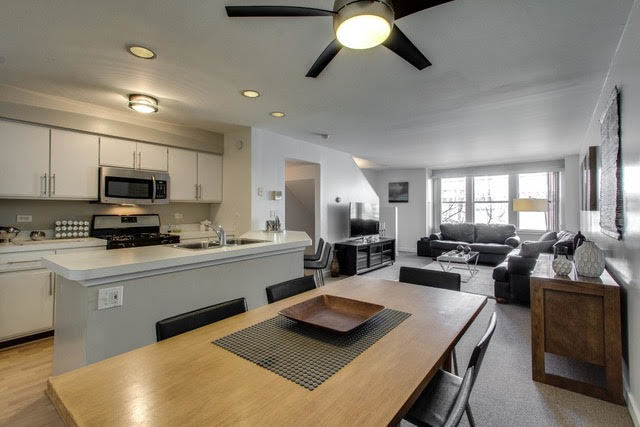 1007 East 61st Street Chicago, IL 60637 - Photo 5 of 20 a living room with stainless steel appliances kitchen island granite countertop furniture and a view of kitchen