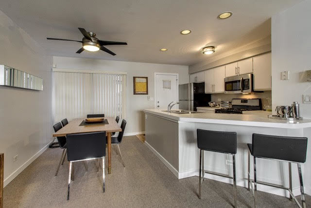 1007 East 61st Street Chicago, IL 60637 - Photo 6 of 20 a kitchen with a dining table chairs and a refrigerator