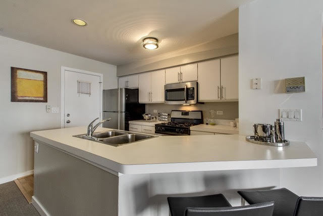 1007 East 61st Street Chicago, IL 60637 - Photo 7 of 20 a kitchen with a sink a stove and chairs