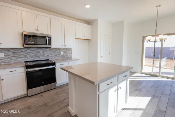 a kitchen with cabinets appliances and a window