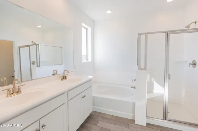 a bathroom with a double vanity sink a mirror and a bathtub