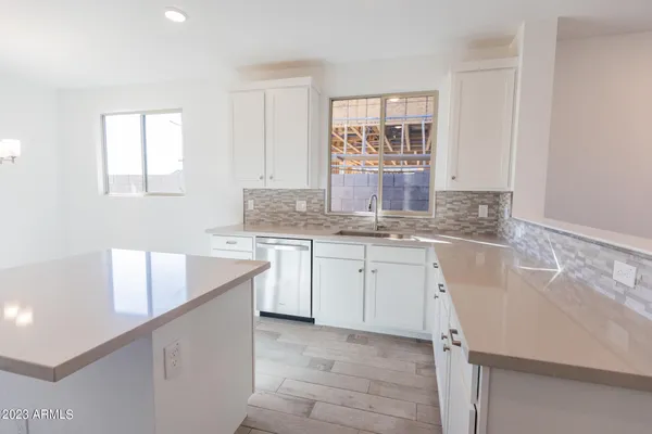 a kitchen with granite countertop white cabinets and white appliances