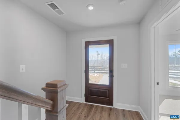 a view of entryway and hall with wooden floor