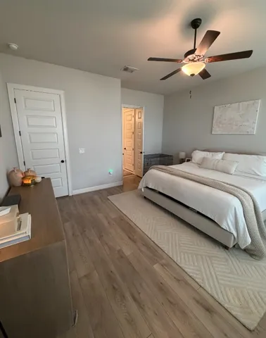a bedroom with a large bed chandelier and a window