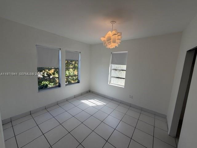2368 Northwest 3rd Street, Unit 4 Miami, FL 33125 - Photo 9 of 20 an empty room with windows and chandelier