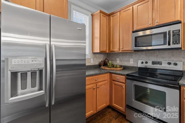 a kitchen with stainless steel appliances granite countertop a stove microwave and cabinets