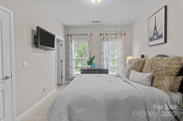 a bedroom with a bed tv and window