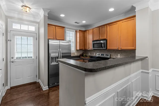a kitchen with stainless steel appliances granite countertop a stove refrigerator and microwave
