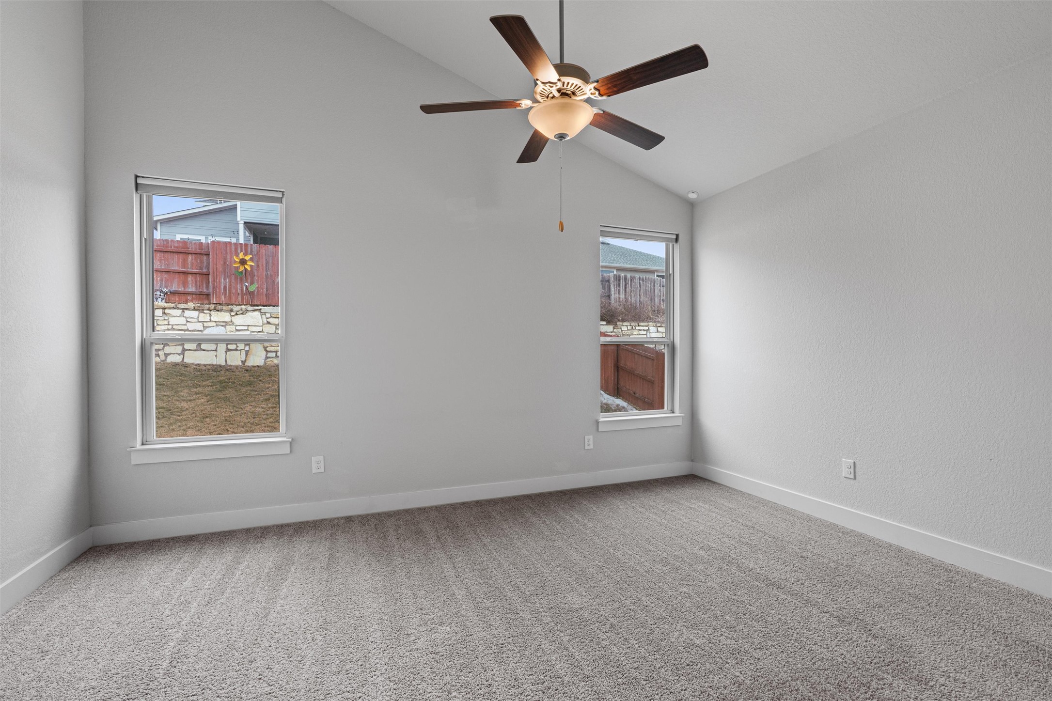 11217 Charger Way Manor, TX 78653 - Photo 14 of 35 Carpeted spare room featuring lofted ceiling and a ceiling fan