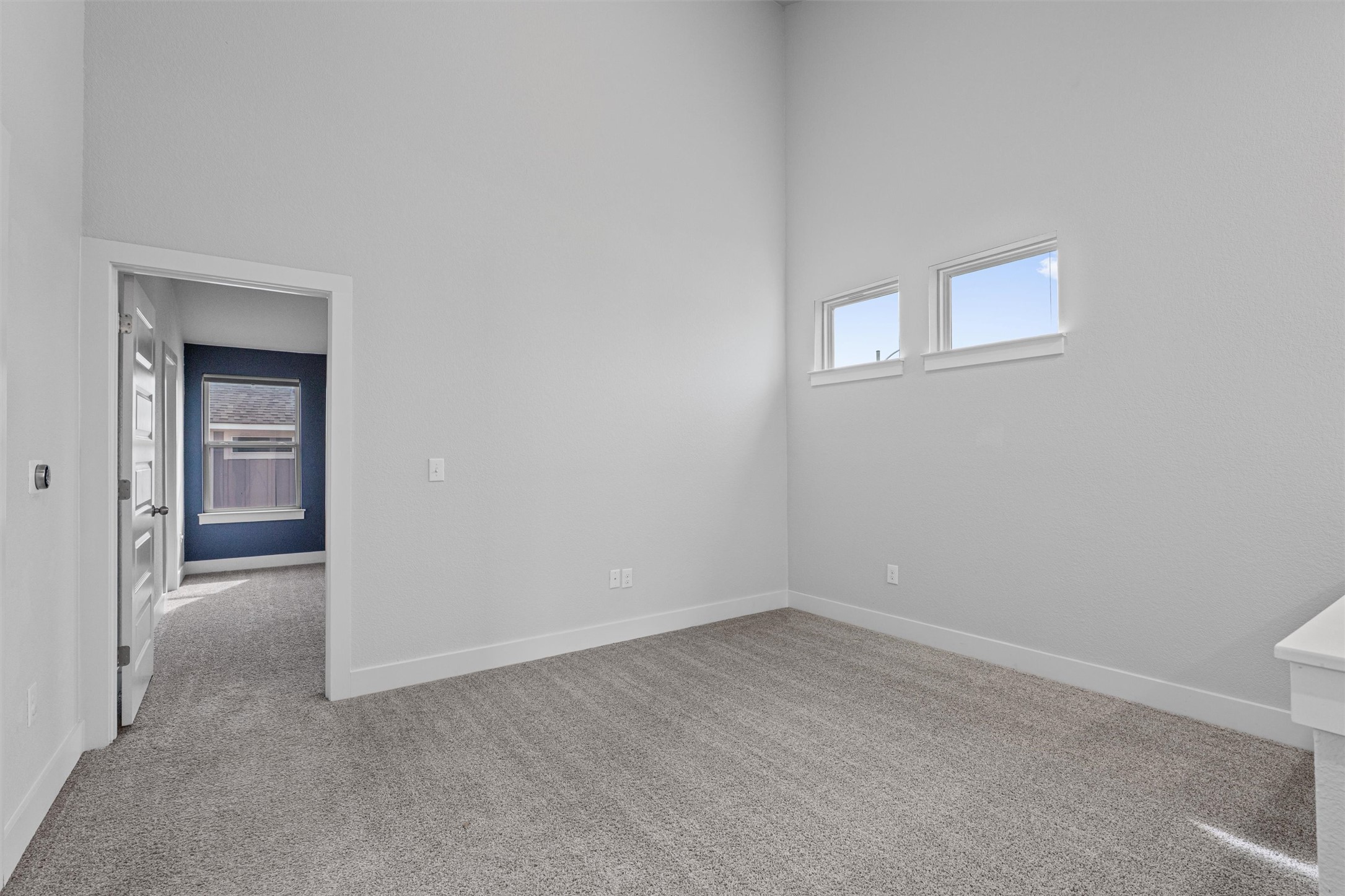 11217 Charger Way Manor, TX 78653 - Photo 22 of 35 Spare room with light colored carpet, plenty of natural light, and a towering ceiling