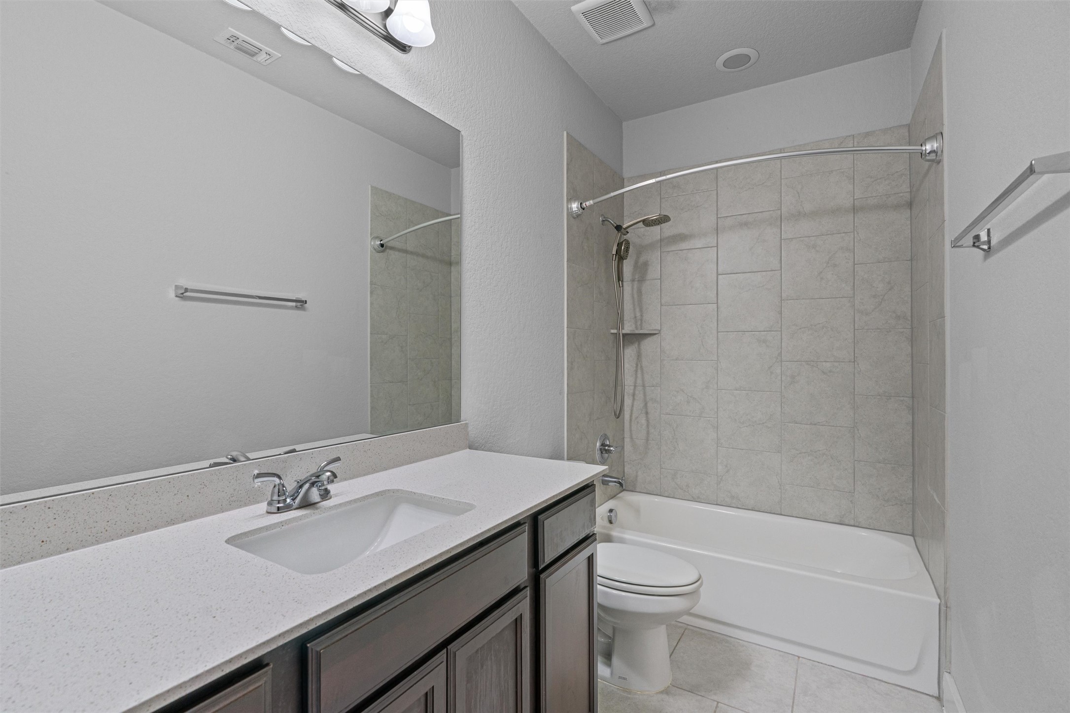 11217 Charger Way Manor, TX 78653 - Photo 26 of 35 Full bathroom with washtub / shower combination, vanity, and light tile patterned flooring
