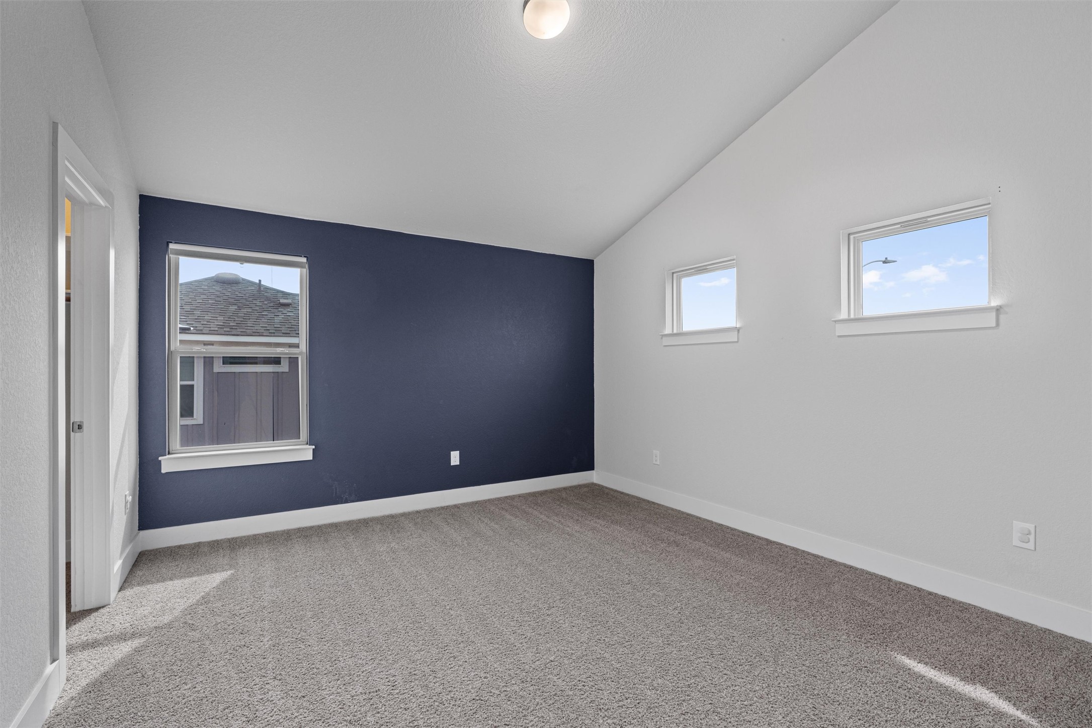 11217 Charger Way Manor, TX 78653 - Photo 27 of 35 Unfurnished bedroom with light colored carpet and lofted ceiling