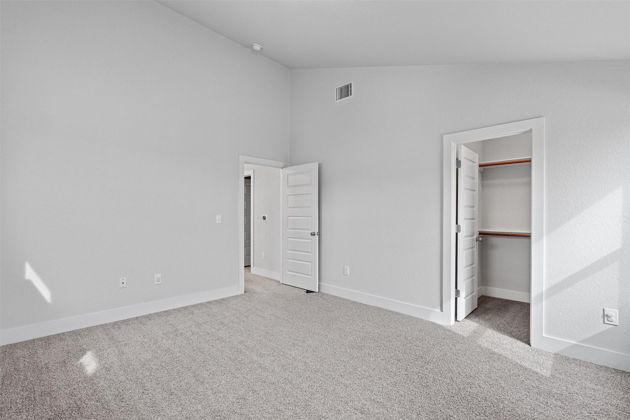 11217 Charger Way Manor, TX 78653 - Photo 28 of 35 Unfurnished bedroom featuring light colored carpet, a walk in closet, and high vaulted ceiling