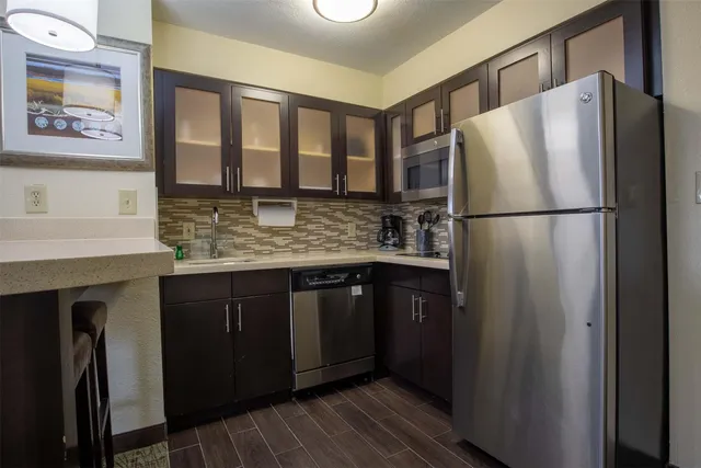 a kitchen with stainless steel appliances granite countertop a refrigerator and a sink