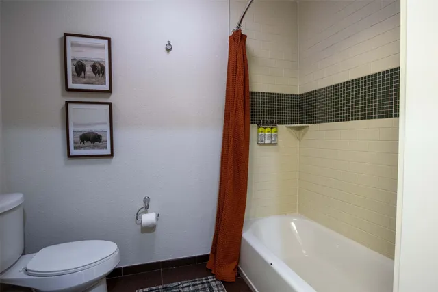 a bathroom with a toilet and a shower