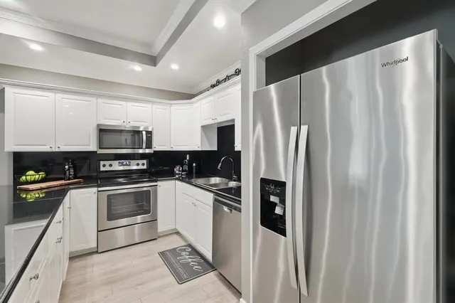 a kitchen with stainless steel appliances granite countertop a refrigerator sink and stove