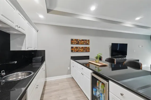 a kitchen with a sink and a stove top oven with wooden floor