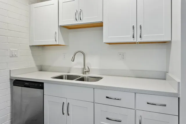 a kitchen with white cabinets and a sink