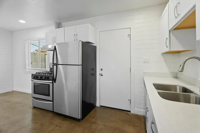 a kitchen with stainless steel appliances a refrigerator and a sink