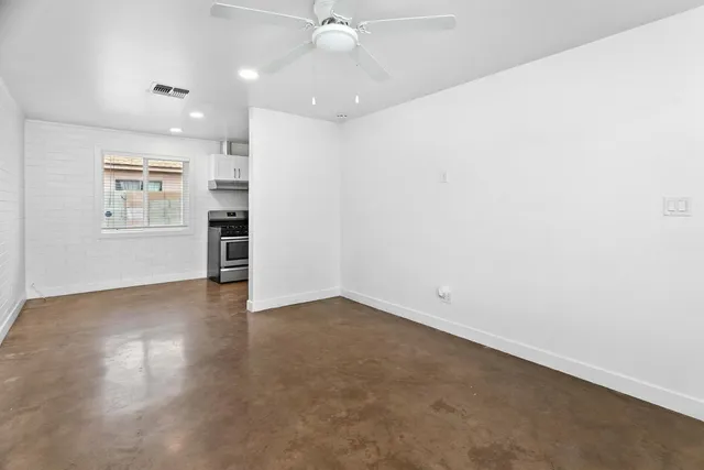 an empty room with a kitchen and a window