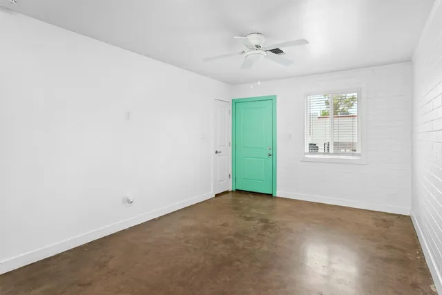 an empty room with a window and a ceiling fan