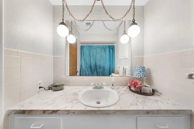 a bathroom with a granite countertop sink and a mirror