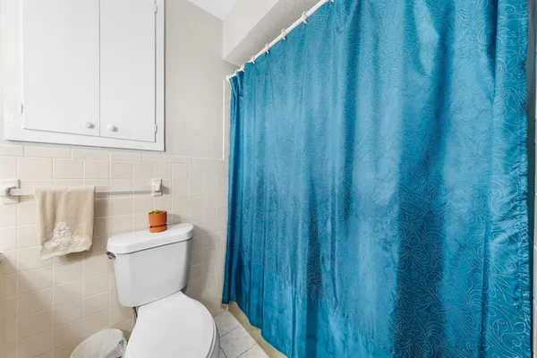 a white toilet sitting next to a wooden cabinet