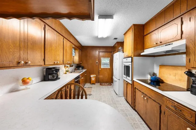 a kitchen with stainless steel appliances a sink a stove and a wooden floors