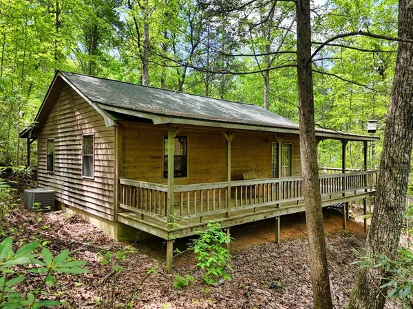 a view of a house with a wooden deck and a yard