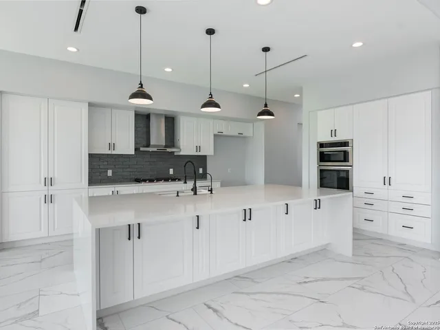 a view of kitchen with white cabinets and stainless steel appliances