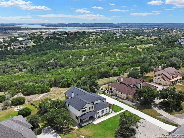 an aerial view of residential houses with outdoor space and ocean view