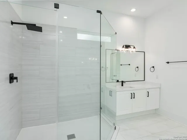 a bathroom with a shower sink and mirror