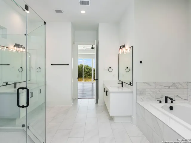 a bathroom with a tub sink vanity and tub