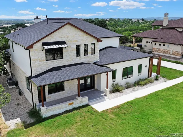 a aerial view of a house with a yard table and chairs