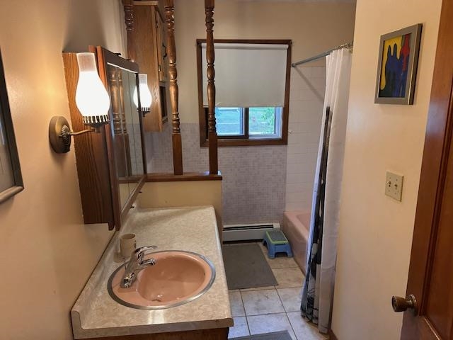 38 Locust Drive Babbitt, MN 55706 - Photo 15 of 29 Full bathroom with vanity, a baseboard heating unit, tile patterned floors, and shower / bath combo