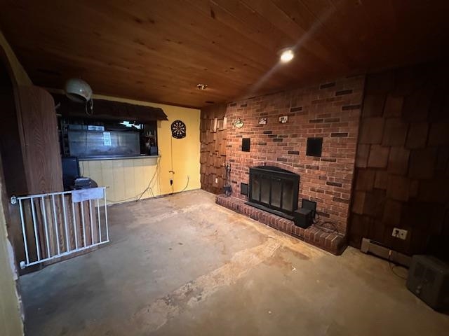 38 Locust Drive Babbitt, MN 55706 - Photo 10 of 29 Unfurnished living room featuring unfinished concrete flooring, a fireplace, and wood ceiling