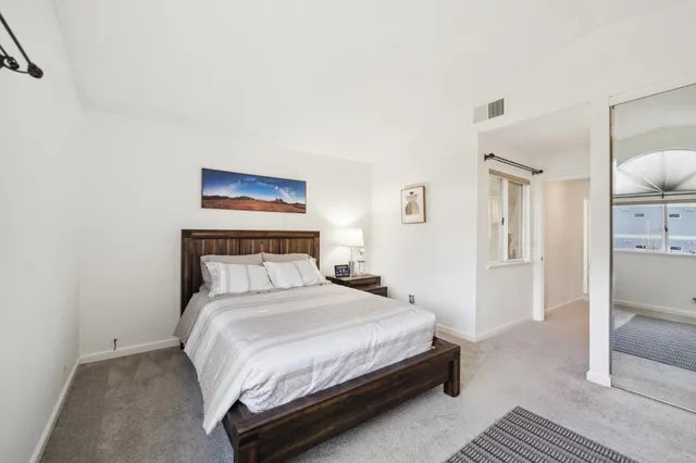 a bedroom with a bed and a painting on the wall