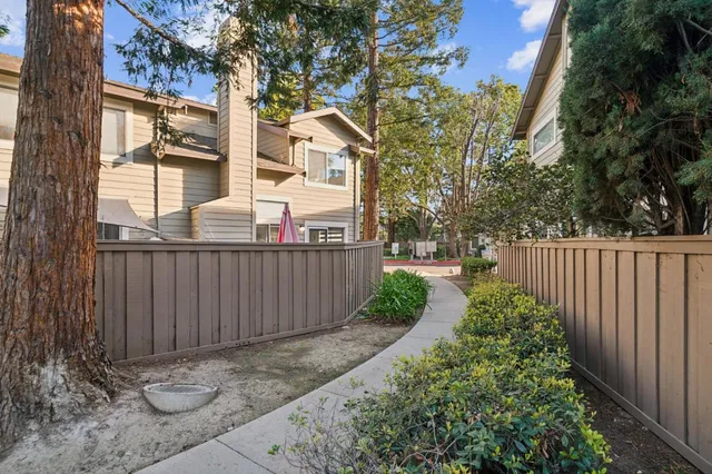 a view of a house with a small yard and wooden fence