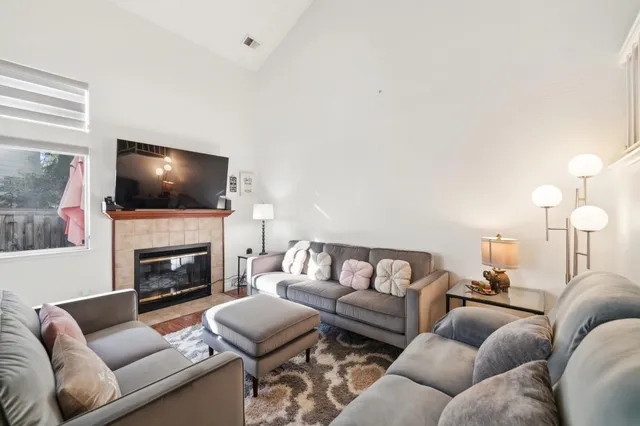 a living room with furniture a fireplace and a flat screen tv