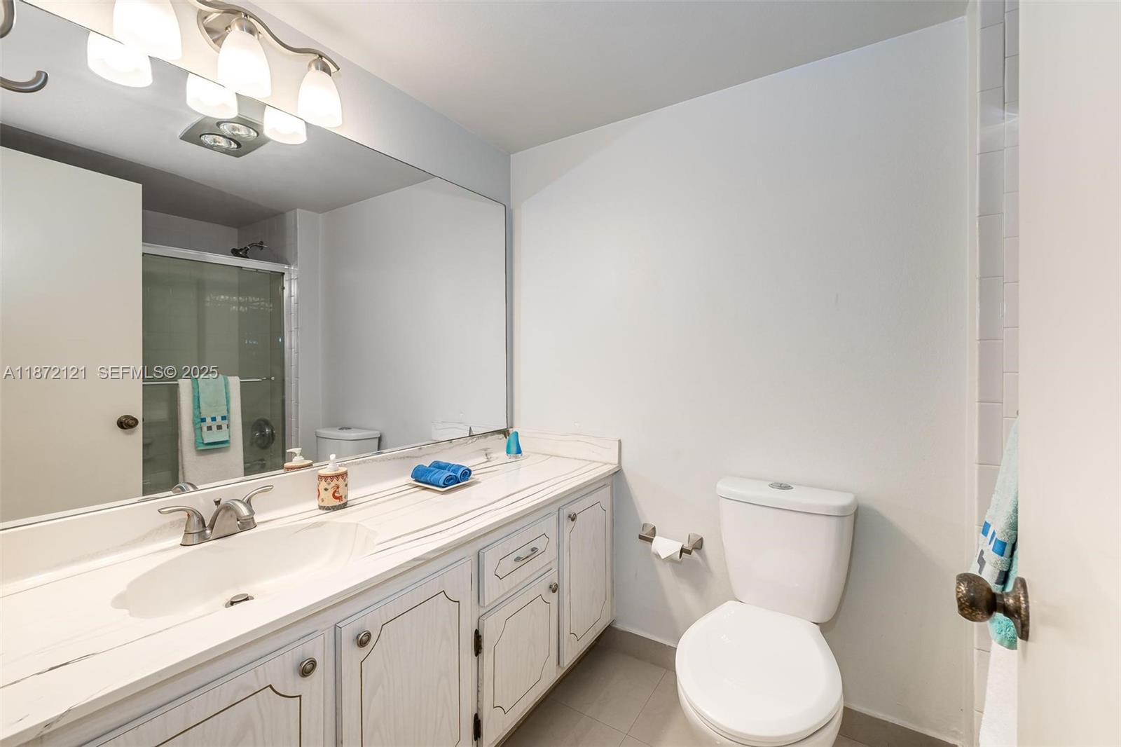 9856 Marina Boulevard, Unit 1320 Boca Raton, FL 33428 - Photo 28 of 48 a bathroom with a double vanity sink toilet and a mirror