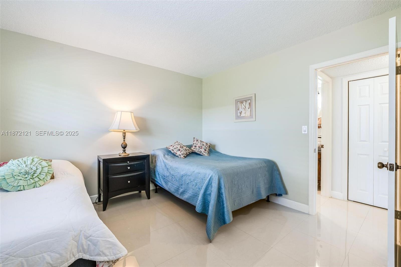 9856 Marina Boulevard, Unit 1320 Boca Raton, FL 33428 - Photo 36 of 48 a bedroom with a bed and a lamp