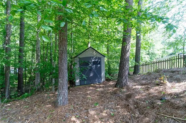 a view of a house with a yard and large trees