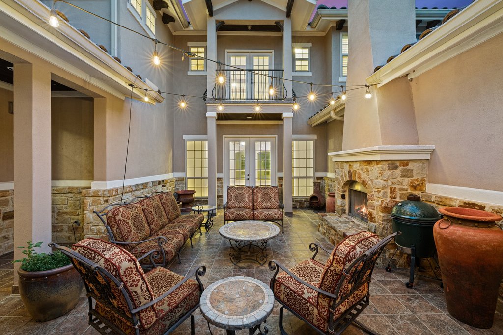 109 Largo Cove Austin, TX 78734 - Photo 28 of 40 An inviting courtyard with an outdoor fireplace and string lighting, perfect for evening gatherings.