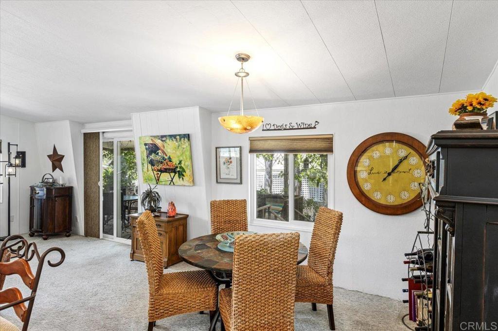 18218 Paradise Mountain Road, Unit 116 Valley Center, CA 92082 - Photo 12 of 35 a dining room with furniture a rug and a window