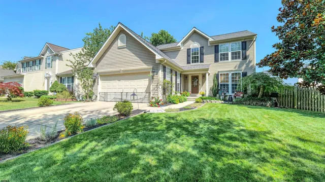 a front view of a house with a yard and fountain