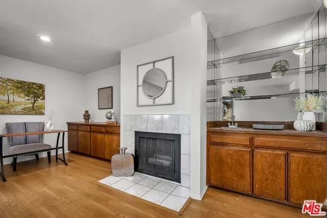 a living room with furniture a fireplace and kitchen view