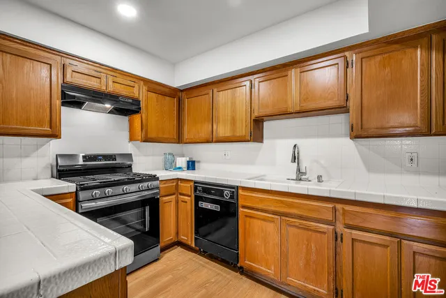 a kitchen with stainless steel appliances granite countertop a refrigerator and a stove top oven