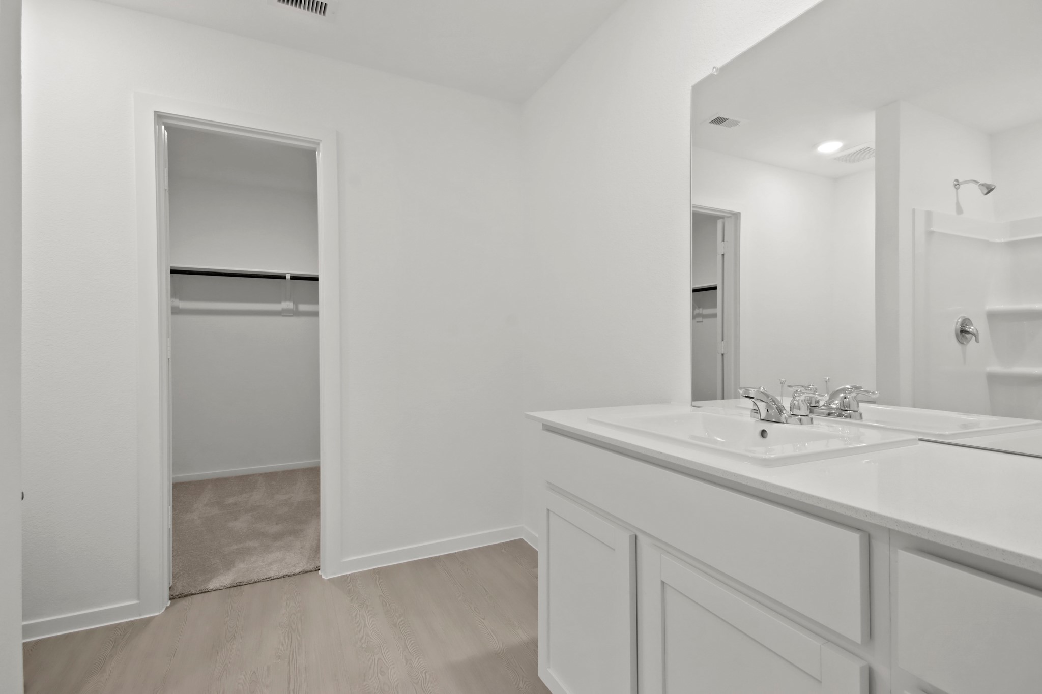 18779 Ribolla Drive New Caney, TX 77357 - Photo 12 of 24 Bright, modern bathroom with dual sinks, a spacious walk-in closet, and sleek fixtures.