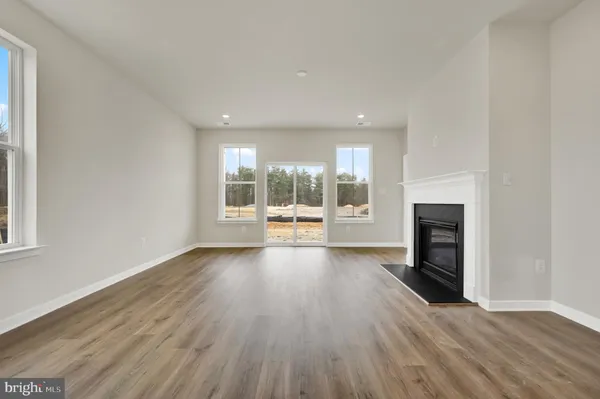 an empty room with wooden floor and a fireplace