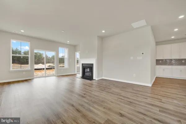 an empty room with wooden floor and fireplace